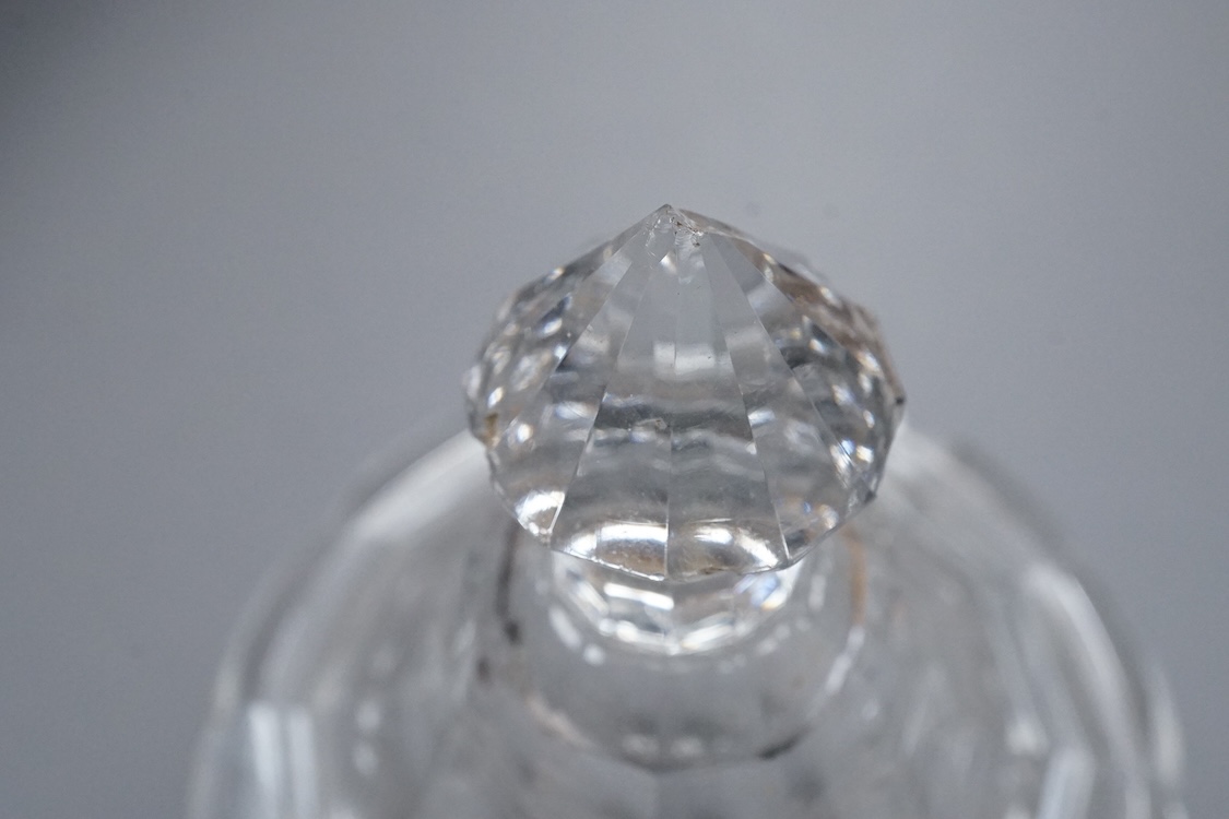 An early 19th century cut glass sweetmeat glass and cover in the shape of an urn, raised on a square pedestal base, with cut out for a spoon to the lid, 21cm high